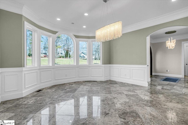 unfurnished dining area featuring ornamental molding and an inviting chandelier