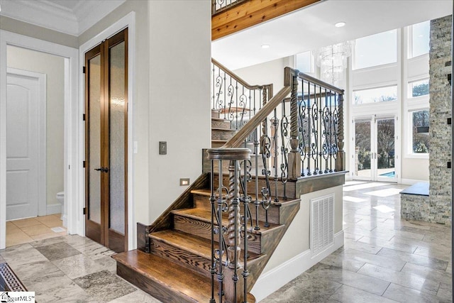 stairs with a high ceiling and french doors