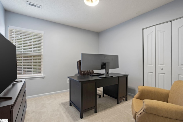 carpeted office space featuring a textured ceiling