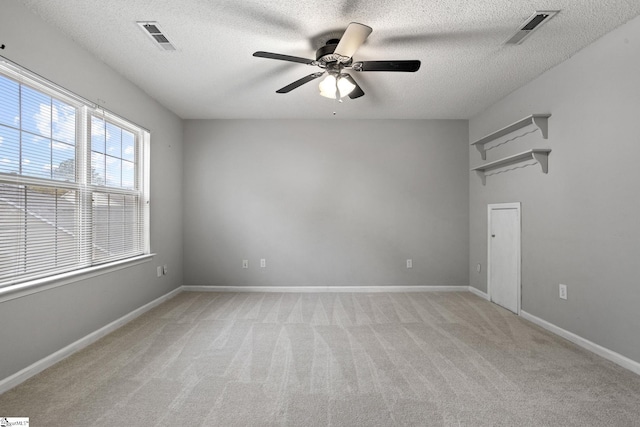 carpeted empty room featuring a textured ceiling and ceiling fan