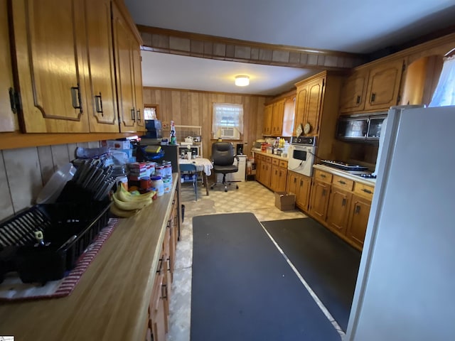 kitchen featuring white appliances and wood walls