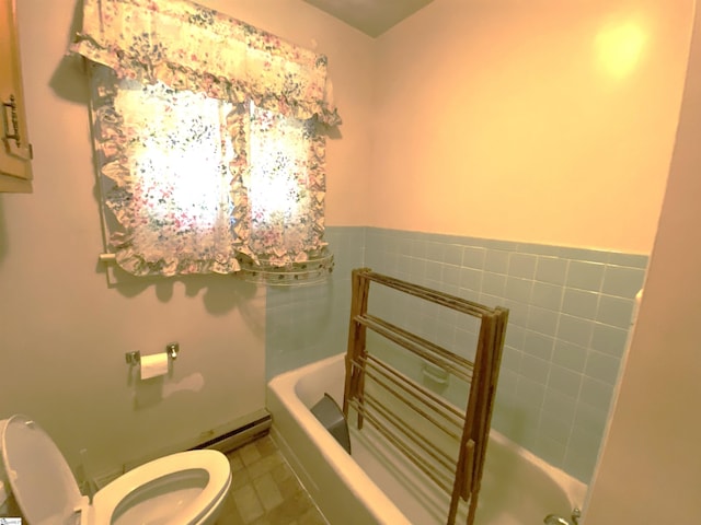 bathroom featuring tile patterned flooring, a bath, and toilet