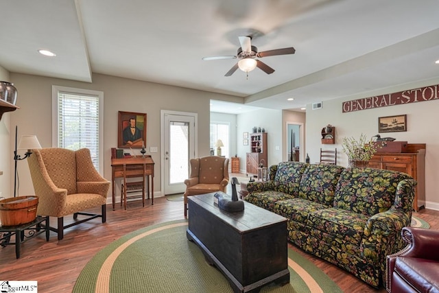 living room featuring ceiling fan, a healthy amount of sunlight, and dark hardwood / wood-style floors