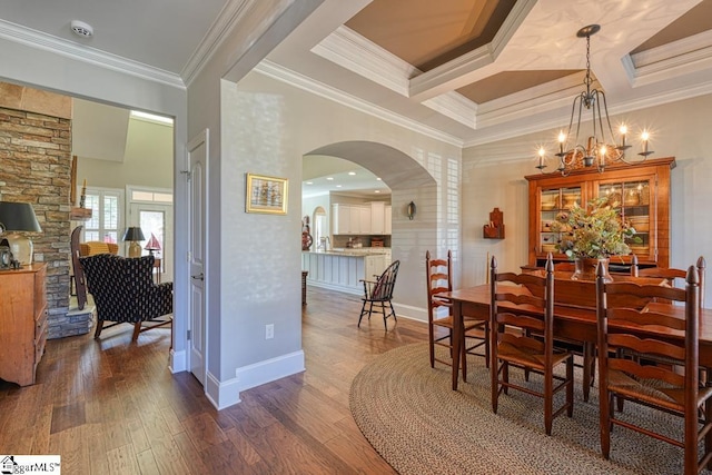 dining room with crown molding, dark wood-type flooring, an inviting chandelier, coffered ceiling, and beamed ceiling