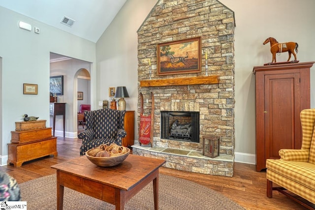 living room with hardwood / wood-style flooring, a fireplace, and high vaulted ceiling