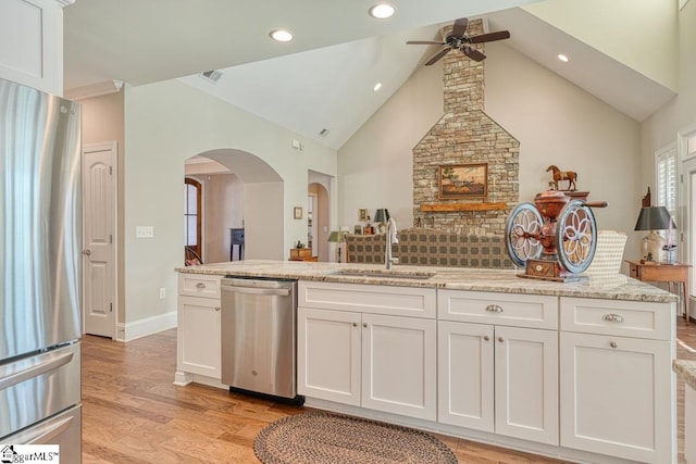 kitchen featuring white cabinetry, stainless steel appliances, light stone countertops, and sink