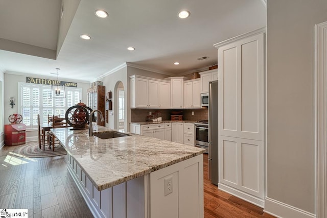 kitchen with a large island, sink, white cabinetry, and dark hardwood / wood-style flooring