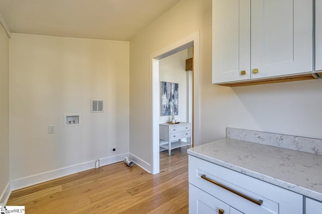 laundry room featuring hookup for a washing machine, electric dryer hookup, cabinets, and light hardwood / wood-style flooring