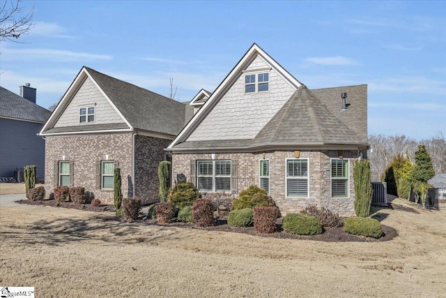 view of front of property with central AC and a front lawn