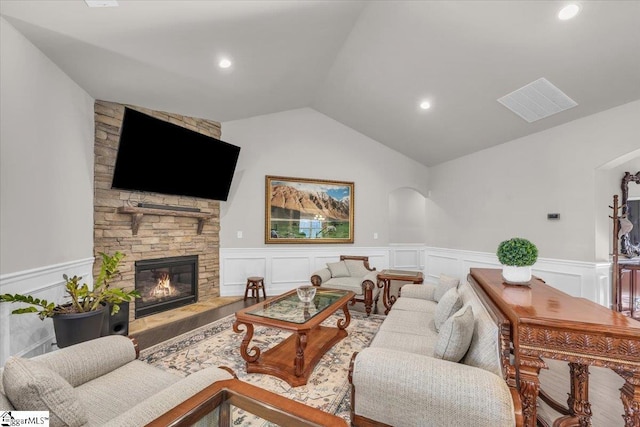 living room featuring lofted ceiling and a fireplace