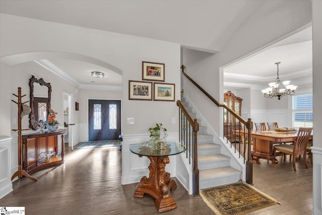 foyer entrance featuring crown molding, dark hardwood / wood-style floors, and an inviting chandelier