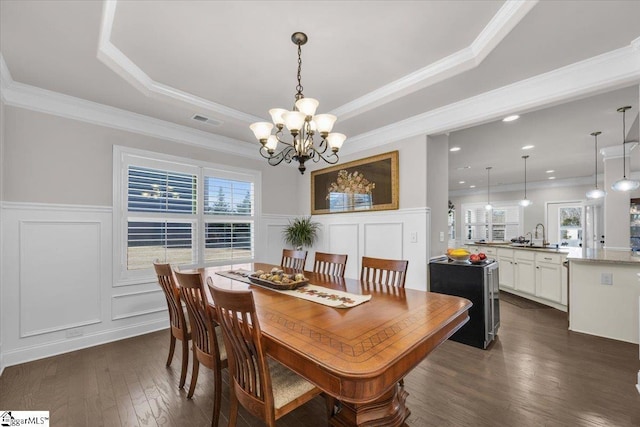 dining room with a notable chandelier, a tray ceiling, a wealth of natural light, and dark wood-type flooring