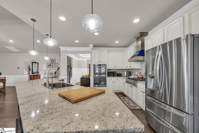 kitchen featuring premium range hood, appliances with stainless steel finishes, decorative light fixtures, sink, and a large island