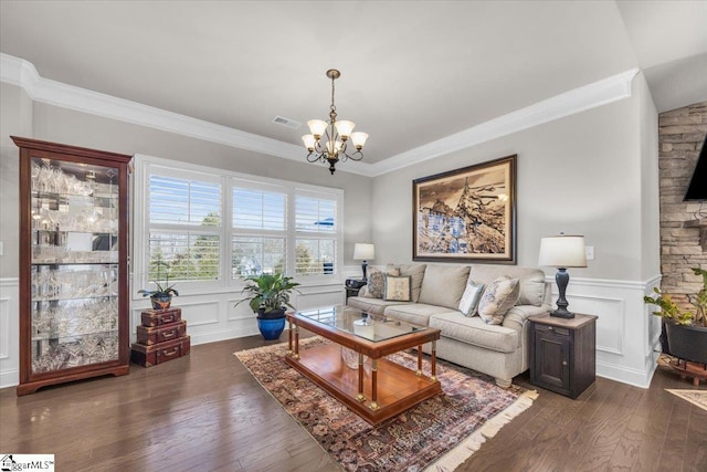 living room featuring crown molding, dark hardwood / wood-style floors, and an inviting chandelier