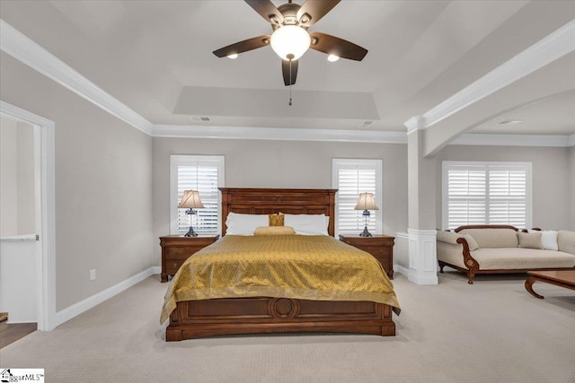 bedroom featuring ceiling fan, light colored carpet, ornamental molding, and a tray ceiling