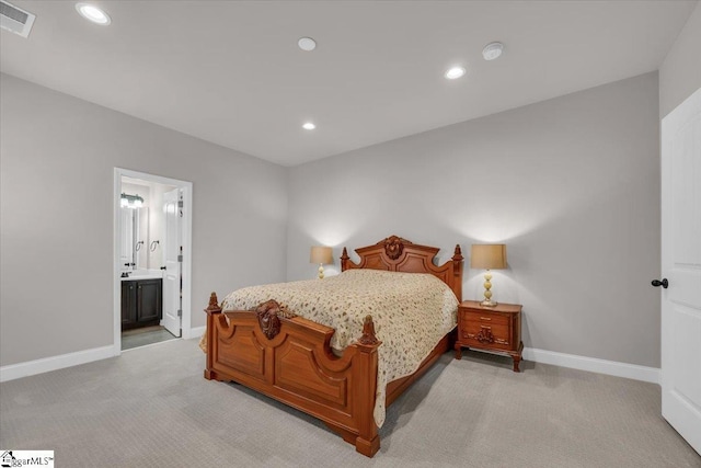 bedroom with connected bathroom and light colored carpet