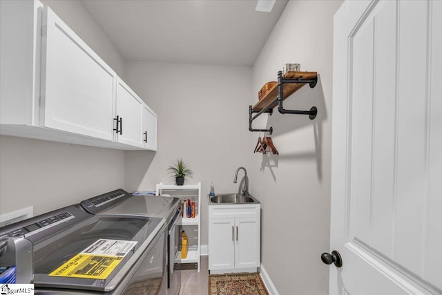 washroom with cabinets, sink, and washing machine and dryer