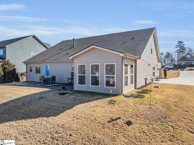 rear view of house with a yard and a patio area