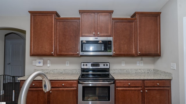 kitchen featuring light stone countertops and stainless steel appliances