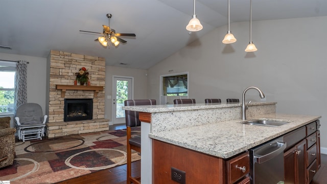 kitchen featuring hanging light fixtures, sink, a kitchen island with sink, and a kitchen breakfast bar