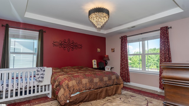 bedroom with a chandelier and a raised ceiling