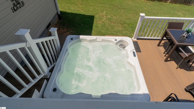 wooden deck featuring a yard and an outdoor hot tub