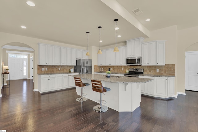 kitchen with white cabinetry, pendant lighting, a center island with sink, and appliances with stainless steel finishes