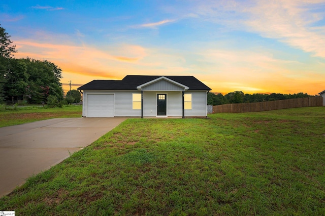 single story home with a garage and a yard