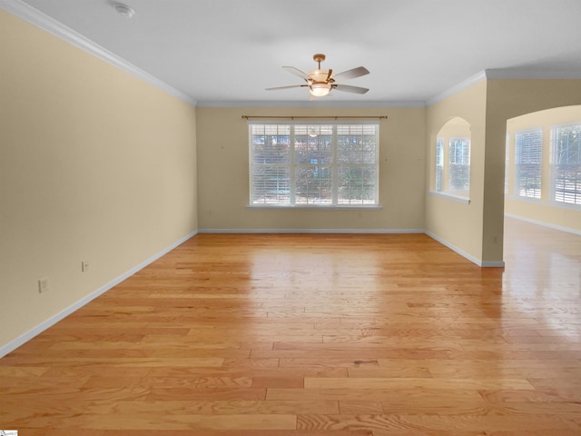 unfurnished room featuring ornamental molding, plenty of natural light, ceiling fan, and light wood-type flooring