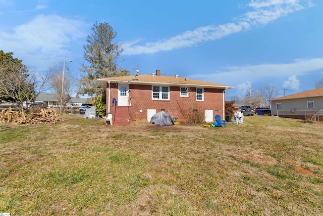 rear view of property featuring a lawn