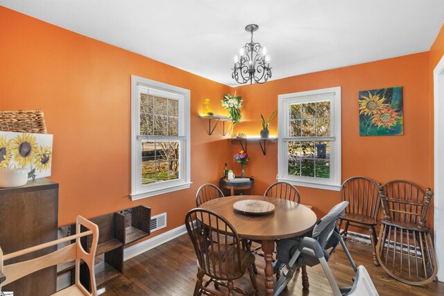 dining room with dark wood-type flooring and a chandelier