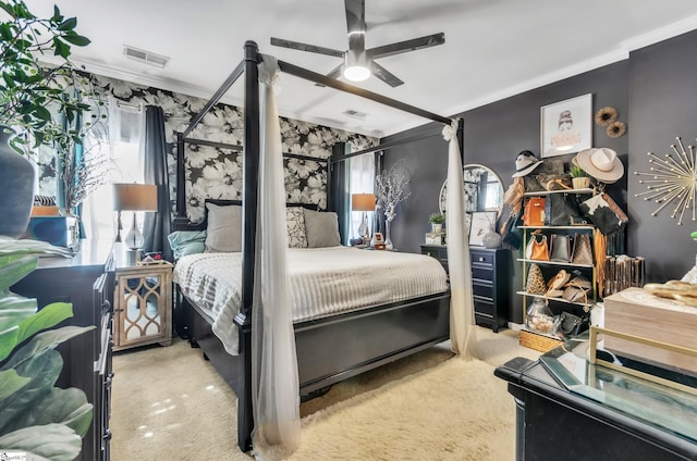 carpeted bedroom with ornamental molding and ceiling fan