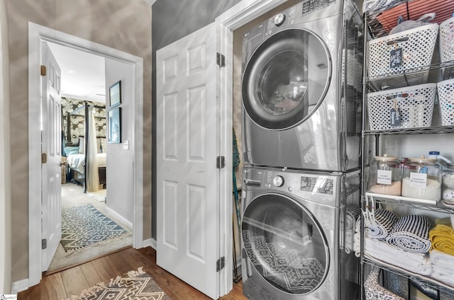 washroom featuring stacked washer / drying machine and hardwood / wood-style floors