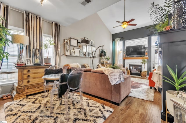 living room featuring vaulted ceiling, light hardwood / wood-style floors, and ceiling fan