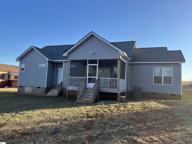 view of front facade featuring a sunroom, central AC unit, and a front lawn