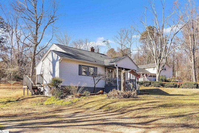 view of property exterior with a porch and a lawn