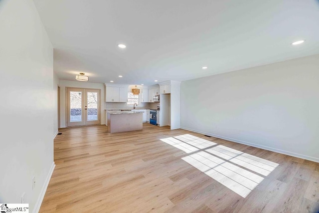 unfurnished living room with french doors and light wood-type flooring