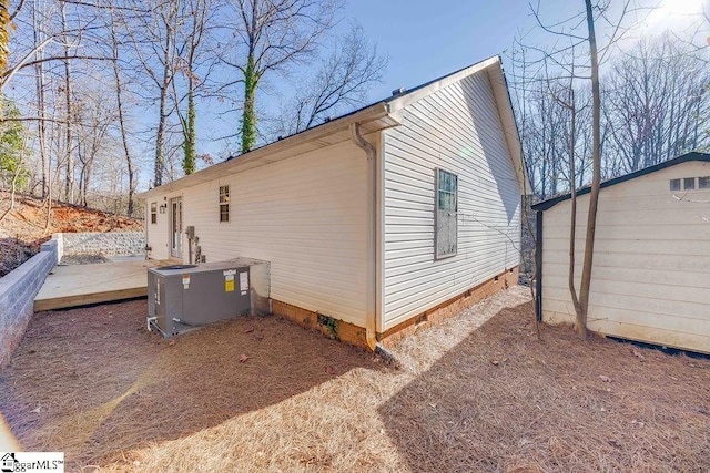 view of side of home with cooling unit and a deck