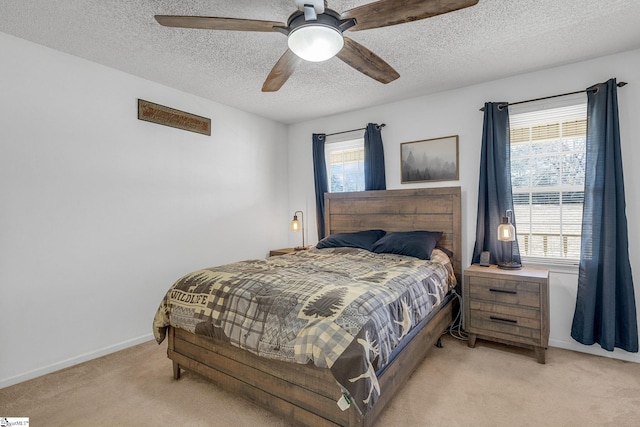 bedroom with ceiling fan, light carpet, and a textured ceiling