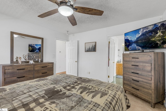 carpeted bedroom with ceiling fan, ensuite bathroom, and a textured ceiling