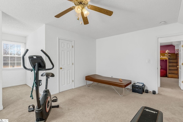 workout area with ceiling fan, light carpet, and a textured ceiling