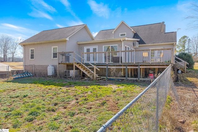 rear view of house with a wooden deck and a yard