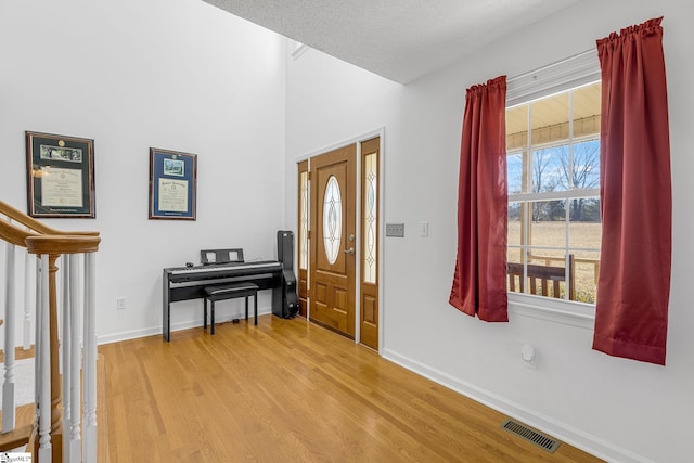 entryway with a textured ceiling and light wood-type flooring