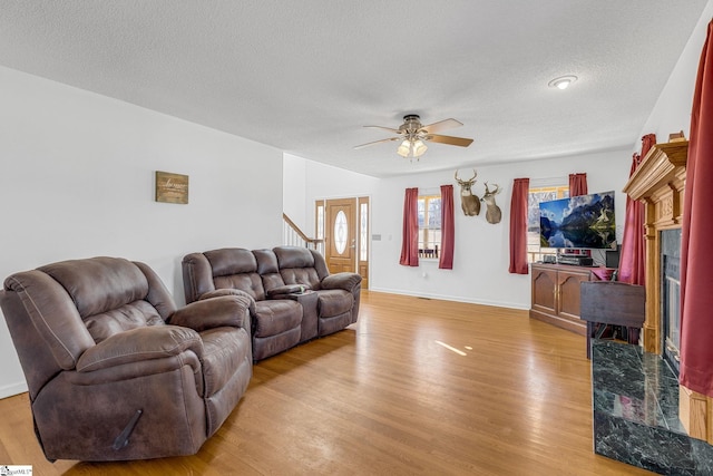 living room featuring a fireplace, light hardwood / wood-style flooring, and a textured ceiling