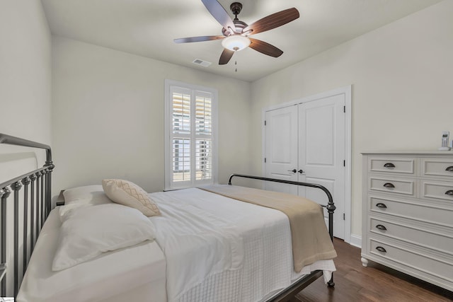 bedroom with ceiling fan, dark hardwood / wood-style flooring, and a closet