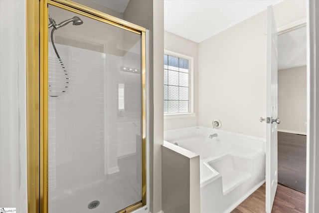 bathroom with wood-type flooring and separate shower and tub