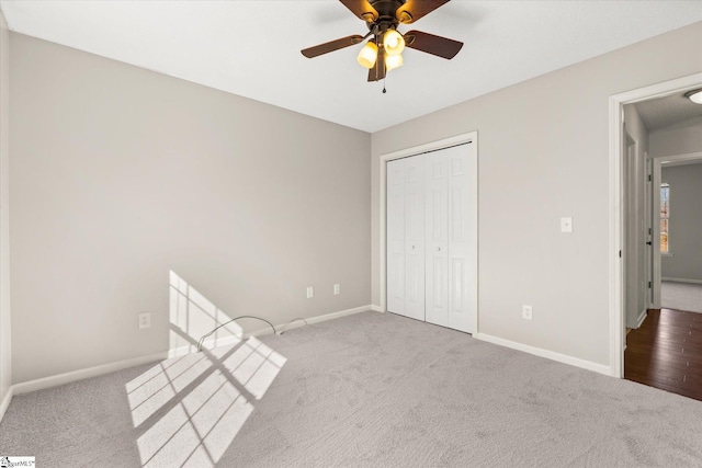 unfurnished bedroom with ceiling fan, light colored carpet, and a closet