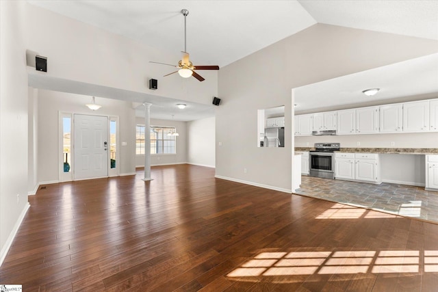 unfurnished living room with decorative columns, wood-type flooring, high vaulted ceiling, and ceiling fan