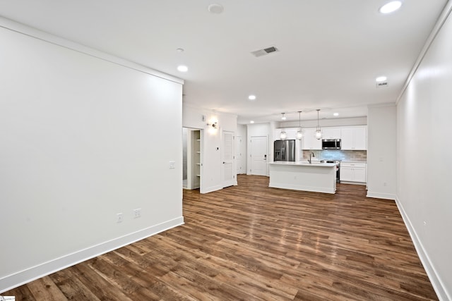 unfurnished living room with crown molding and dark wood-type flooring