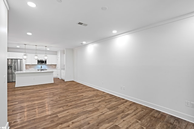 unfurnished living room featuring dark hardwood / wood-style flooring and sink